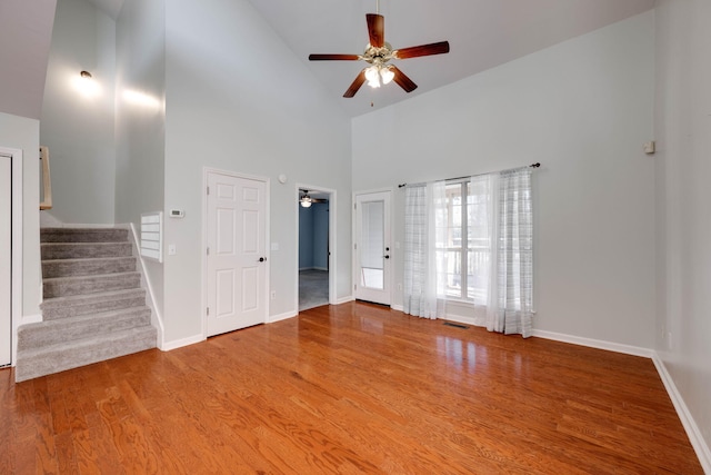 unfurnished living room featuring hardwood / wood-style floors, high vaulted ceiling, and ceiling fan