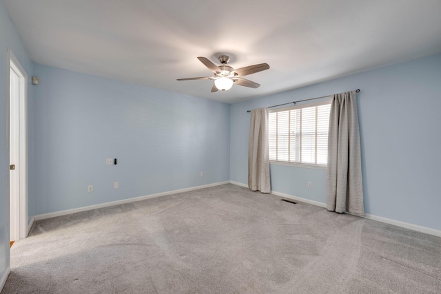 carpeted spare room featuring ceiling fan