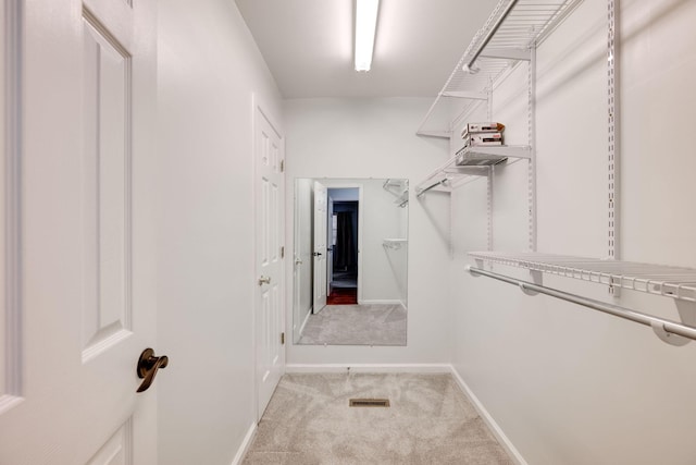 walk in closet featuring light carpet