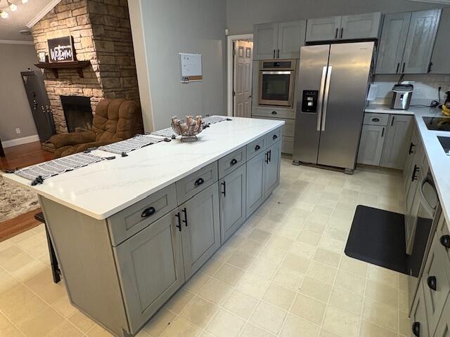 kitchen featuring stainless steel appliances, gray cabinets, and crown molding