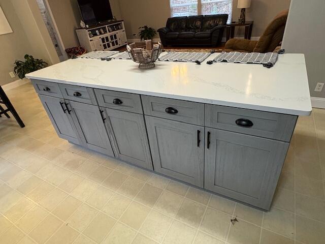 kitchen with gray cabinetry and light stone counters