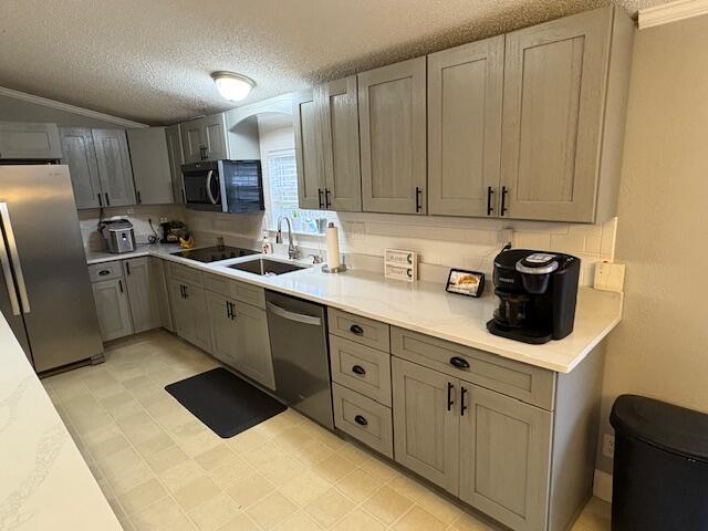 kitchen featuring crown molding, sink, gray cabinets, a textured ceiling, and appliances with stainless steel finishes