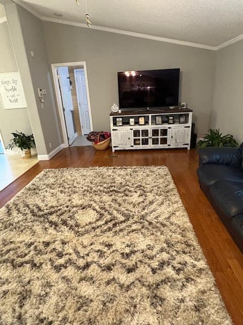 living room featuring crown molding, dark hardwood / wood-style flooring, and a textured ceiling