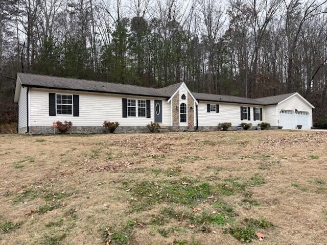 single story home featuring a garage and a front lawn