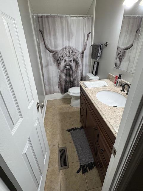 full bathroom featuring tile patterned flooring, vanity, toilet, and shower / tub combo with curtain