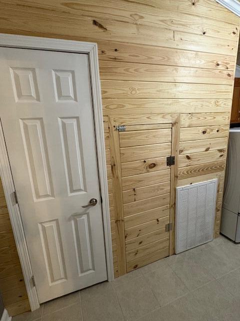 interior space featuring wood walls and light tile patterned flooring