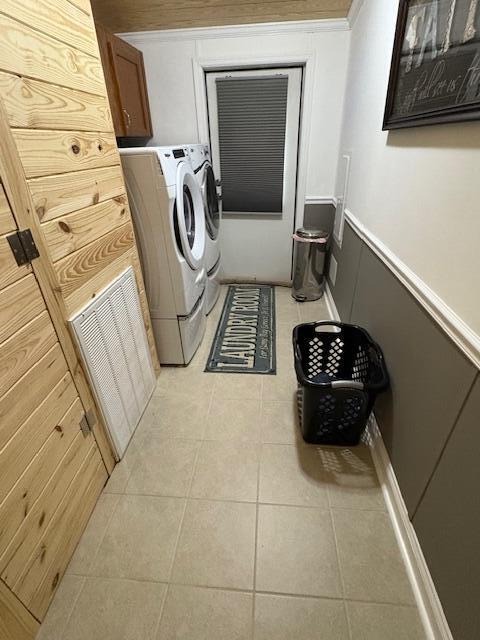 laundry area with cabinets, light tile patterned floors, and washing machine and clothes dryer