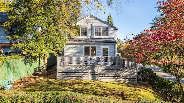 view of front property with a wooden deck and a front lawn