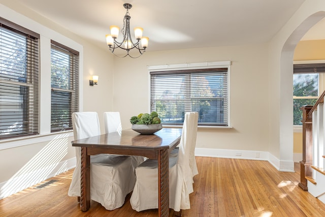 dining room featuring plenty of natural light, light hardwood / wood-style flooring, and a notable chandelier