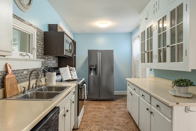 kitchen featuring appliances with stainless steel finishes, white cabinetry, and sink