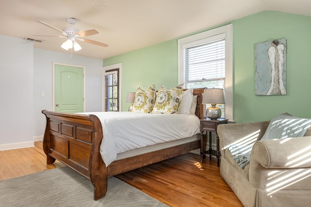 bedroom featuring ceiling fan, multiple windows, and light hardwood / wood-style flooring