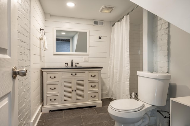 bathroom featuring walk in shower, tile patterned floors, wood walls, toilet, and vanity