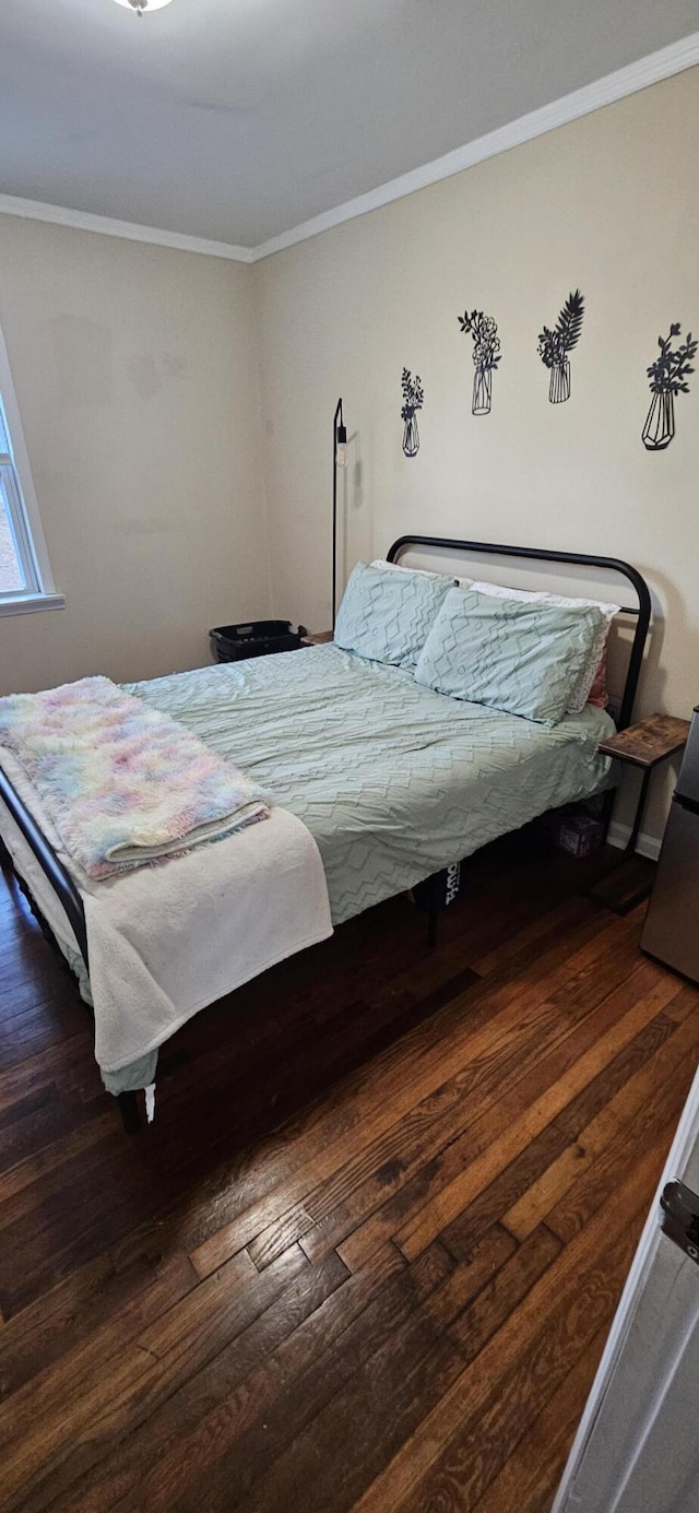 bedroom featuring ornamental molding and dark wood-type flooring