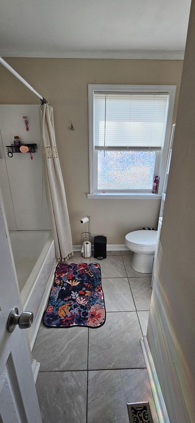 bathroom featuring tile patterned floors, toilet, and shower / tub combo