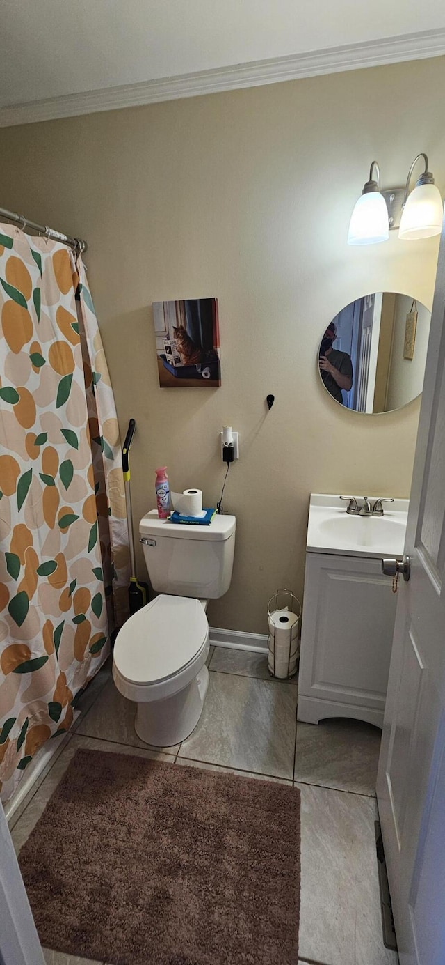 bathroom with tile patterned floors, vanity, toilet, and crown molding