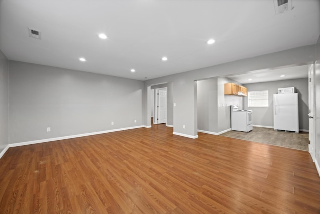 unfurnished living room with washer / dryer and light hardwood / wood-style flooring