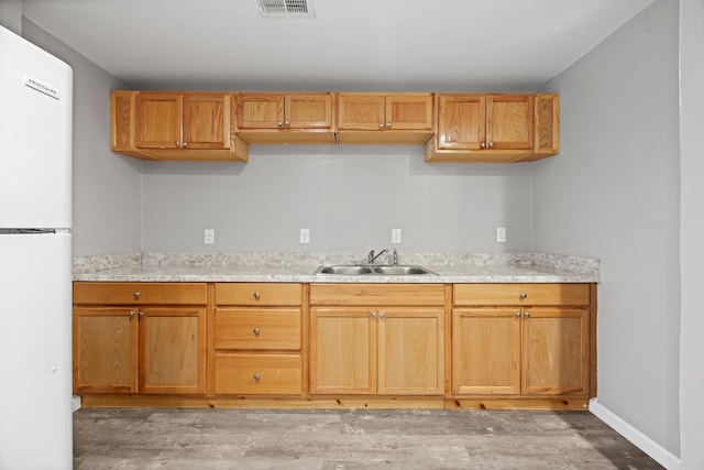 kitchen featuring white refrigerator, sink, and light hardwood / wood-style flooring