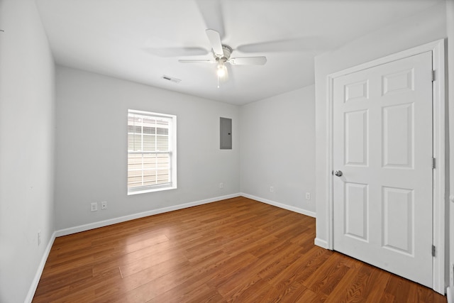 spare room featuring wood-type flooring, electric panel, and ceiling fan