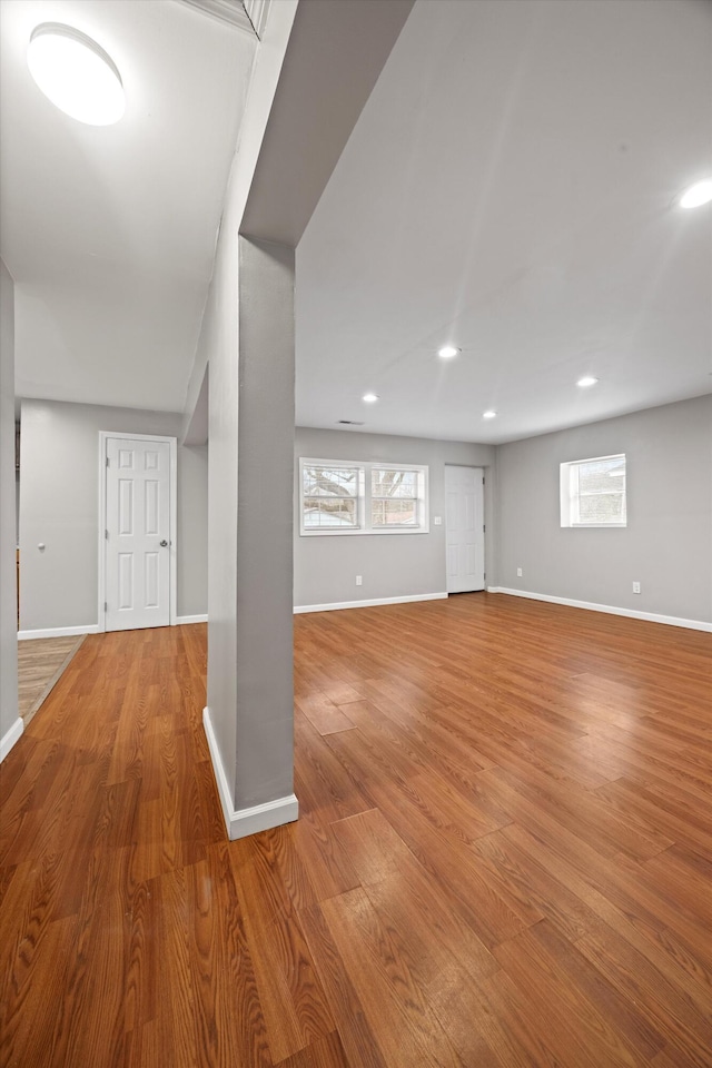 basement featuring plenty of natural light and light hardwood / wood-style flooring