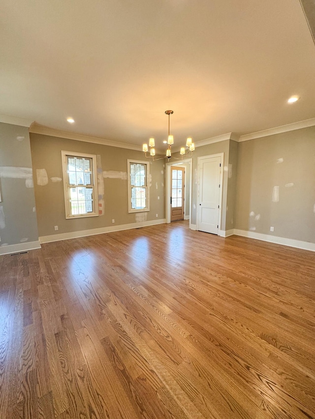 spare room featuring plenty of natural light, light hardwood / wood-style floors, and a notable chandelier