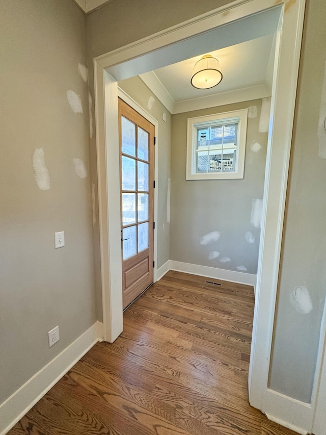 doorway with hardwood / wood-style floors, ornamental molding, and french doors