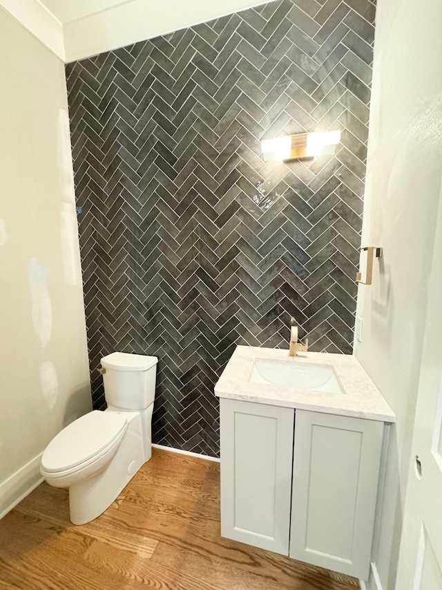 bathroom featuring wood-type flooring, vanity, and toilet