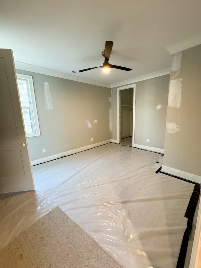 empty room with ceiling fan and crown molding