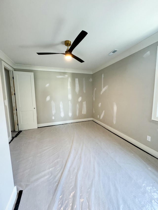 unfurnished room featuring ceiling fan and ornamental molding