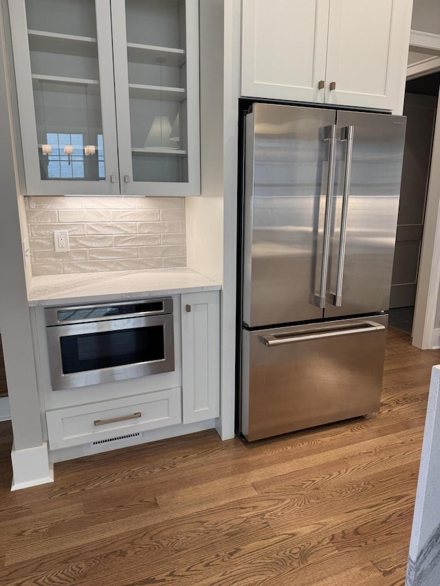 9418 Haviland Way, Ooltewah, TN 37363 - kitchen with high quality fridge, dark wood-style flooring, glass insert cabinets, white cabinets, and decorative backsplash