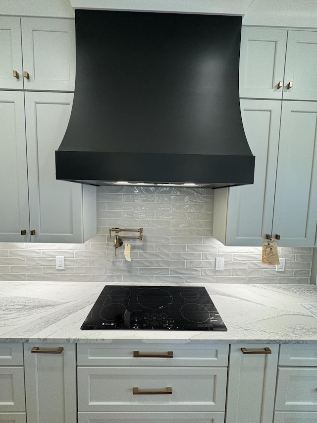 9418 Haviland Way, Ooltewah, TN 37363 - kitchen featuring exhaust hood, black electric cooktop, light stone countertops, and decorative backsplash