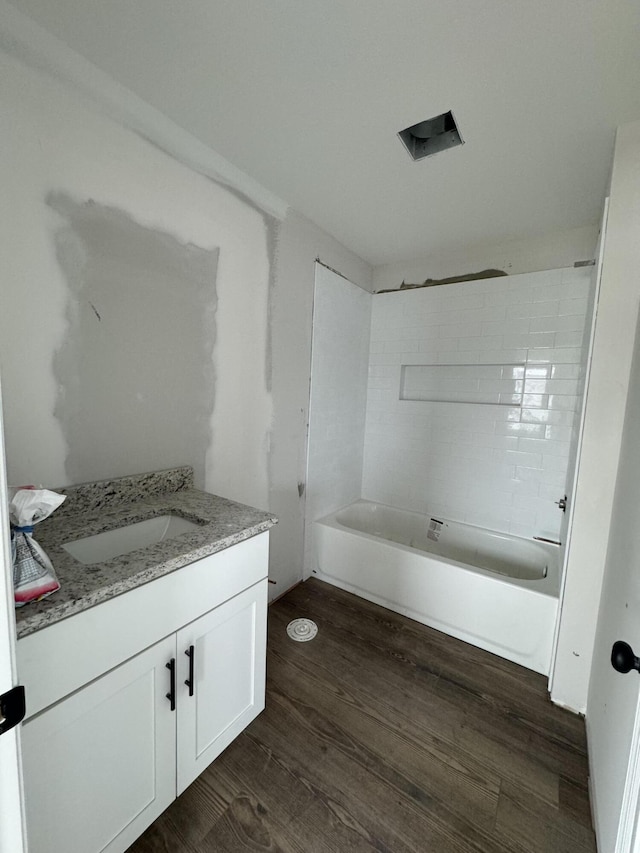 bathroom with vanity, wood-type flooring, and tiled shower / bath combo