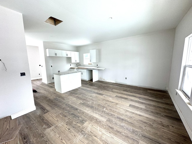 kitchen featuring kitchen peninsula, white cabinetry, and dark hardwood / wood-style flooring