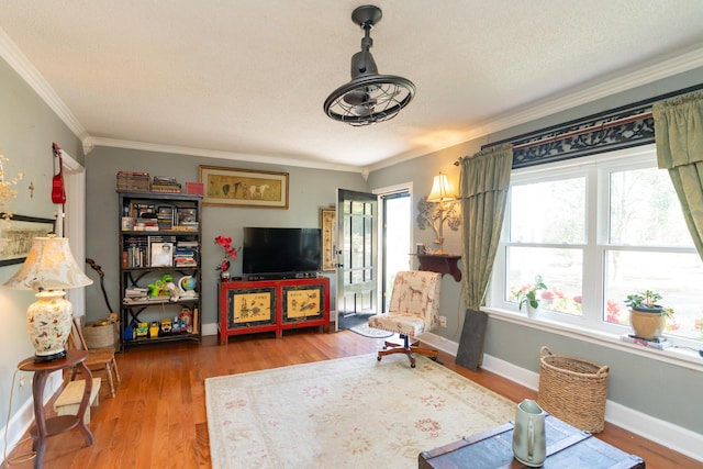 living area with hardwood / wood-style floors and ornamental molding