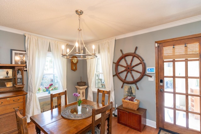 dining room featuring wood-type flooring, a notable chandelier, and ornamental molding