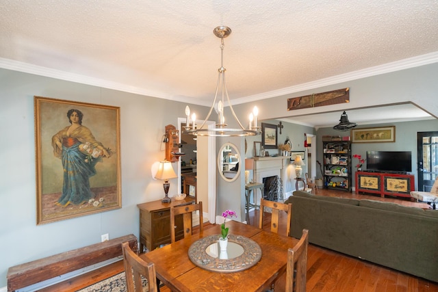 dining room featuring a chandelier, a textured ceiling, hardwood / wood-style flooring, and crown molding