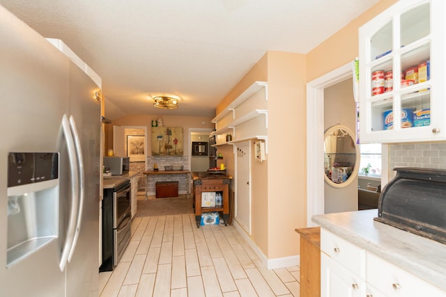 kitchen featuring appliances with stainless steel finishes, light wood-type flooring, and white cabinetry