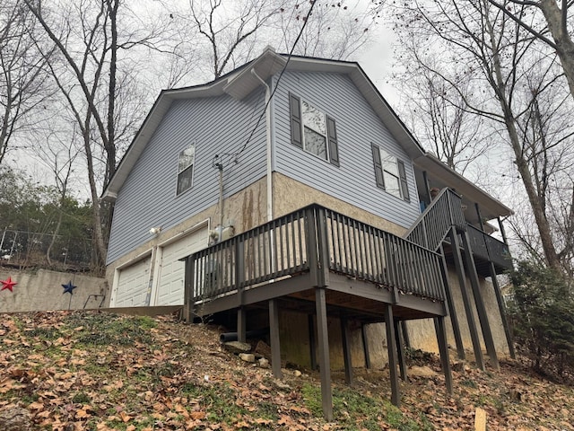 rear view of property with a garage and a deck