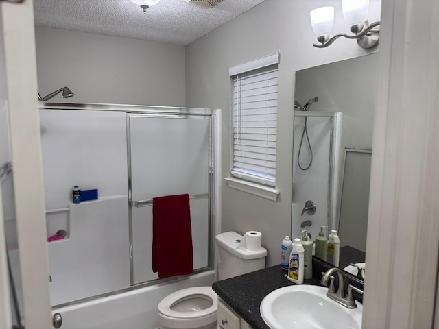 full bathroom featuring vanity, shower / bath combination with glass door, an inviting chandelier, toilet, and a textured ceiling