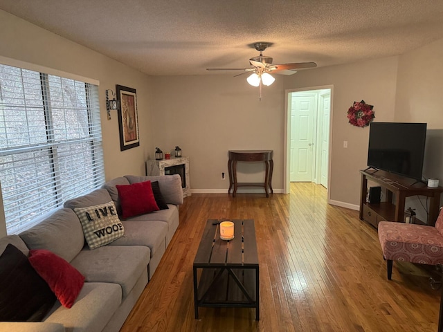 living room featuring ceiling fan, hardwood / wood-style floors, and a textured ceiling