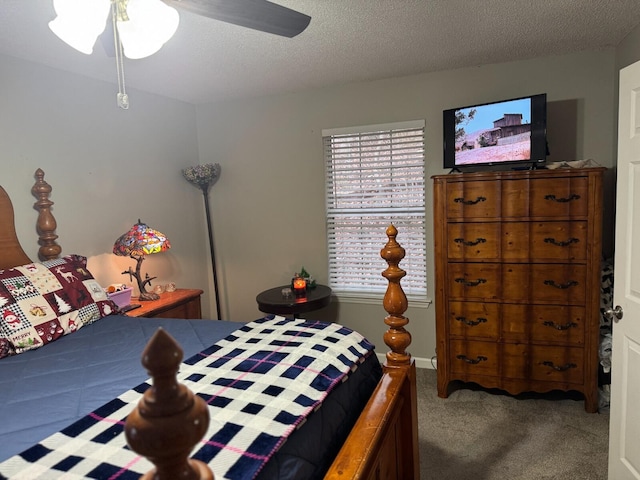 carpeted bedroom featuring ceiling fan and a textured ceiling