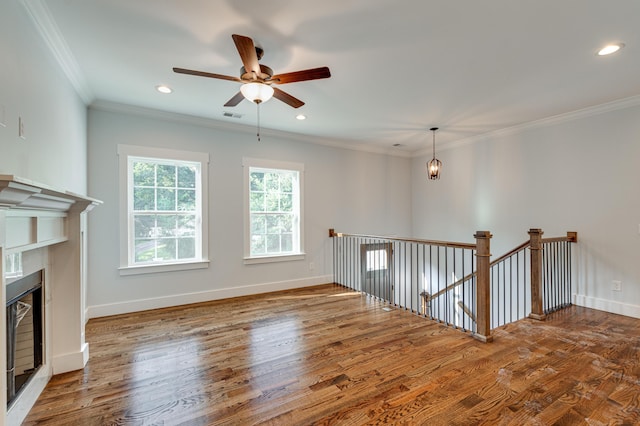 unfurnished living room featuring hardwood / wood-style flooring, ceiling fan, and ornamental molding