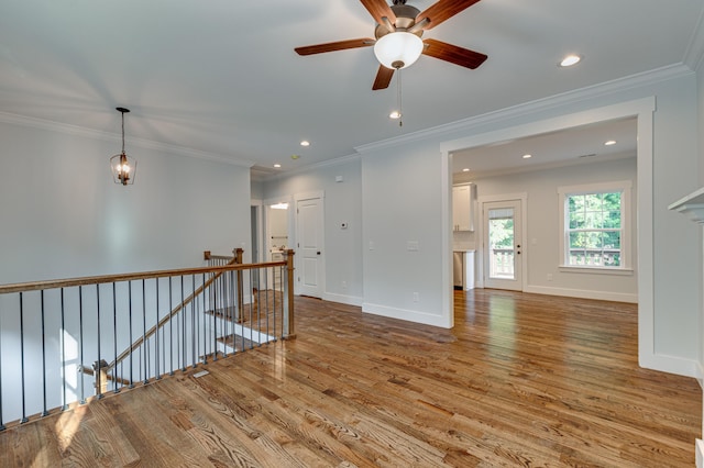 spare room with crown molding, ceiling fan, and light wood-type flooring