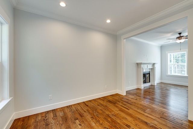 unfurnished living room featuring hardwood / wood-style floors, ceiling fan, and crown molding