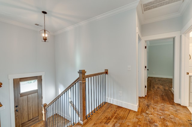 interior space with hardwood / wood-style floors, crown molding, and a notable chandelier