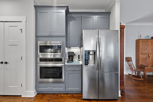 kitchen with appliances with stainless steel finishes, ornamental molding, and gray cabinetry