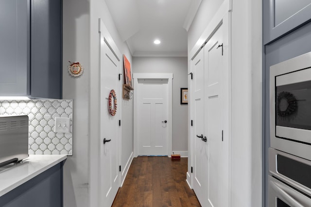 hallway with crown molding and dark wood-type flooring