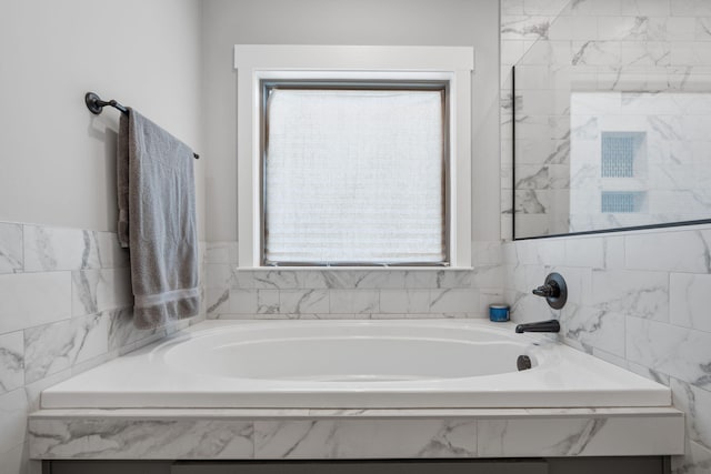 bathroom with a wealth of natural light and tiled tub