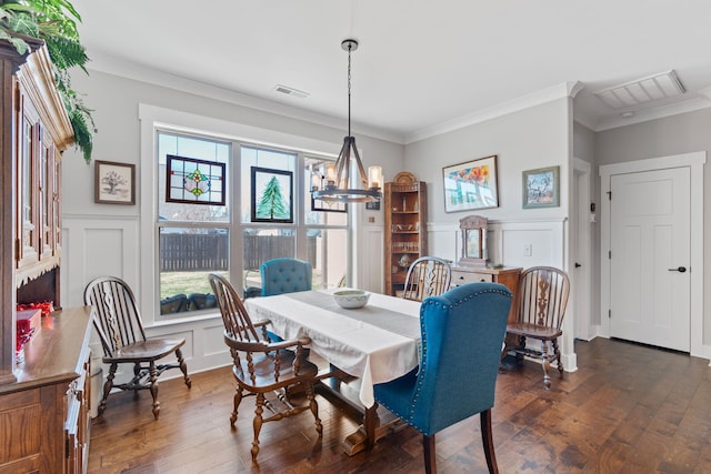 dining area featuring crown molding, dark wood-type flooring, and a notable chandelier