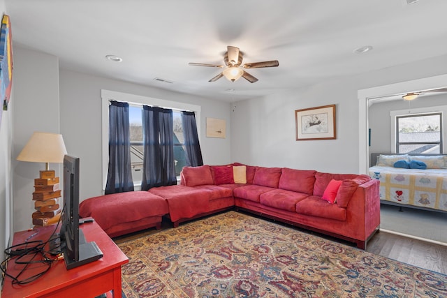 living room with dark hardwood / wood-style floors and ceiling fan