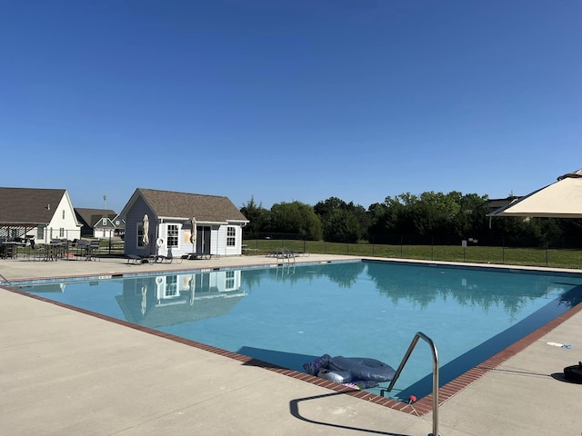 view of pool with an outbuilding and a patio